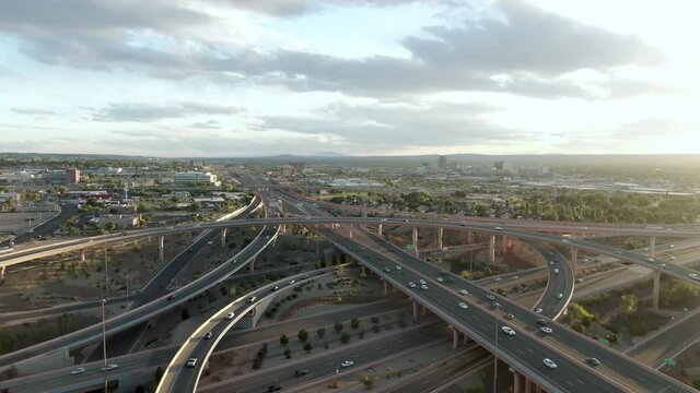 Aerial Tilt Down Shot Of Vehicles On Bridges In City At Sunset Against Sky, Drone Ascending Forward Over Cars In City - Albuquerque, New Mexico