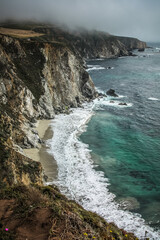 Scenic shot of the beautiful Big Sur Coast of California on a misty day, United States of America aka USA. Foamy waves in the ocean and rocky mountains