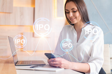 Attractive businesswoman in white shirt using smart phone to optimize trading strategy at corporate finance fund. Forex chart hologram over modern office background