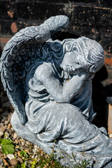 Obraz premium Close and selective focus of an angel statuette in a private back yard with intentional shallow depth of field and bokeh