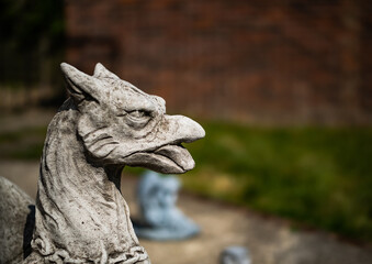 Close and selective focus of a griffin statuette in a private back yard with intentional shallow depth of field and bokeh