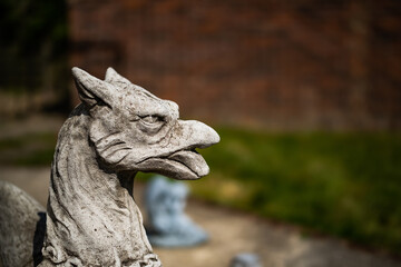 Close and selective focus of a griffin statuette in a private back yard with intentional shallow depth of field and bokeh