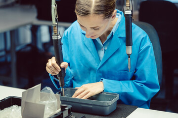 Woman in factory assembling a product