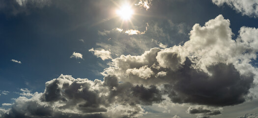 beautiful wide panoramic view of cloudy sky with bright sun above