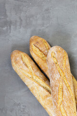 From above photo of french baguette bread on grey concrete background . Diagonal. Copyspace for text