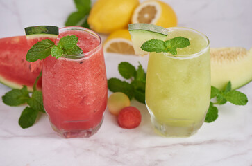 Refreshing summer citrus cocktail with lemon, watermelon and melon with mint and ice cubes in glass, homemade smoothies fresh fruit, fruit drink for healthy concept, selective focus.