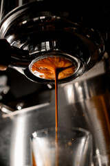 Delicious freshly ground morning espresso pouring through bottomless portafilter into glass.