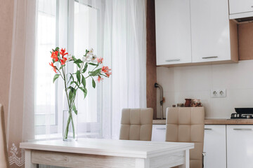 modern light white kitchen with flowers in the vase