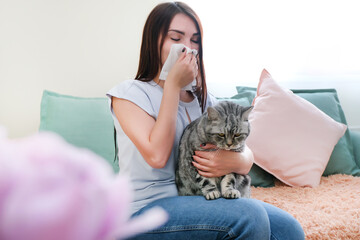 young woman is sneezing from fur allergy