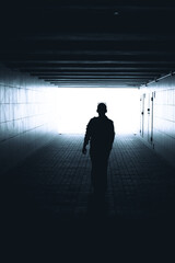 Fototapeta na wymiar Silhouette of a woman walking in the underpass