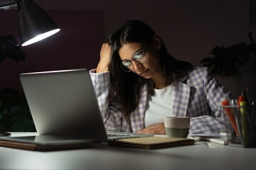 Overworked Indian mixed-race businesswoman suffering from headache and thinking how to end work...