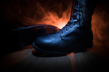 War concept. Old military shoe in a dark toned foggy background. Creative concept of conflict...