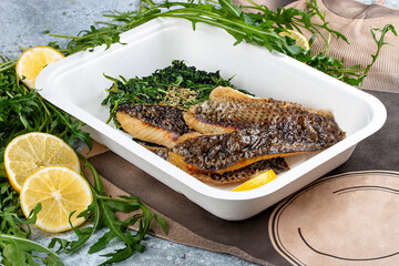 Sea bass fillet with blanched spinach. Diet and healthy food  in eco containers. Takeaway.