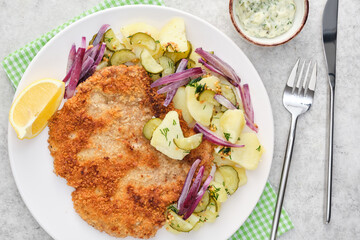 Vienna schnitzel with potatoes and onions.