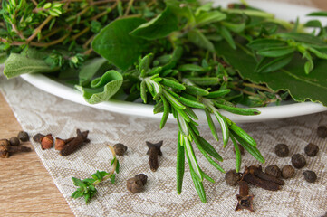 Herbes de Provence and spices on a white porcelain plate.