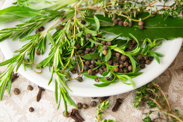 Herbes de Provence and spices on a white porcelain plate.