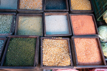 Varitey of dried beans and lentils in square boxes at market stall in Bhaktapur in Nepal. Healthy vegetarian dried foods for sale.