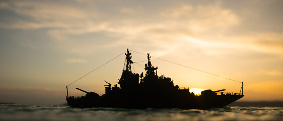 Silhouettes of a crowd standing at blurred military war ship on foggy background. Selective focus.