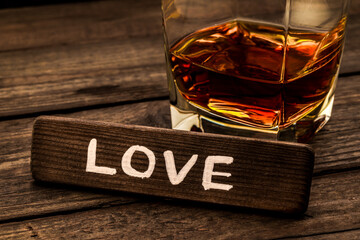 Glass of brandy with the wooden plank on it is an inscription 