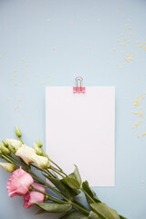 Summer background: Stationery card with eustoma flowers close up on blue background. Copy space. Beauty concept. High quality photo