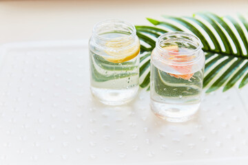 Handmade summer drinks with tropical flowers. Hard seltzer with lemon and grapefruit. Homemade summer cocktails concept on white background. High quality photo