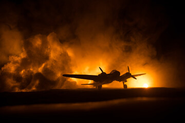 German Junker (Ju-88) night bomber at night. Artwork decoration with scale model of jet-propelled plane in possession. Toned foggy background with light. War scene.