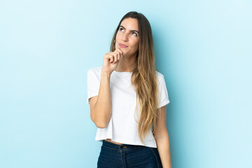 Fototapeta premium Young caucasian woman over isolated background and looking up