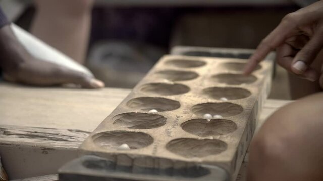 Ourli Board Game in Cabo Verde played between a man an a women