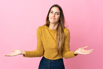 Young caucasian woman isolated on pink background having doubts