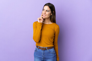 Young caucasian woman over isolated background thinking an idea while looking up