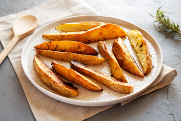 Homemade Rosemary Potato Wedges on a plate, side view.