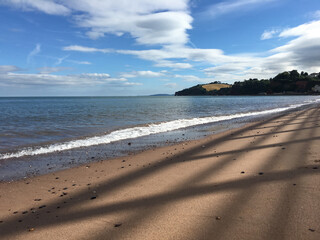 Shadows on Dawlish Town Beach with blue sky and cumulus clouds in background