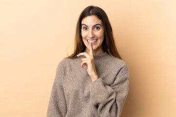 Young caucasian woman over isolated background showing a sign of silence gesture putting finger in mouth