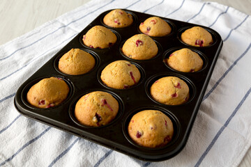 Homemade Cranberry Muffins with Orange Zest in a baking pan, low angle view.