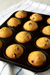Homemade Cranberry Muffins with Orange Zest in a baking pan, side view.