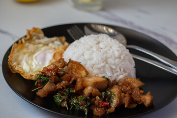 Holy Basil Rice with Crispy Pork and Fried Egg in Black Dish