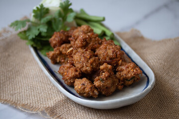 Fried Pork Larb (lab tod) in long plates on a white background.Spicy Thai food of Isan region.