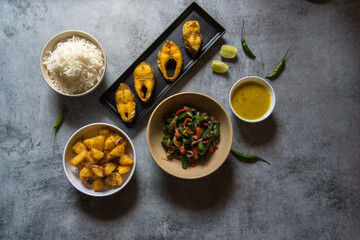 Indian lunch food ingredients rice fish vegetables and pulses with use of selective focus. A pure Bengali cuisine