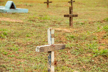 Algumas cruzes sobre túmulos em cemitério.
