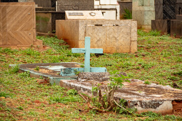 Um túmulo com uma cruz azul em um cemitério.