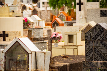 Detalhes de cruzes e túmulos em um cemitério.
