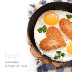 Fried eggs with slices of bread in the shape of a heart in the frying pan