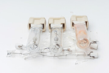 Halogen lamp on a white background. Burned out broken light bulbs. Details of the halogen light...