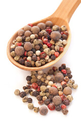 Peppercorns in the wooden spoon over white background