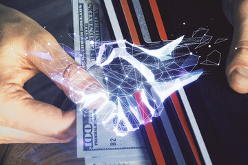 Multi exposure of handshake drawing hologram and USA dollars bills and man hands.