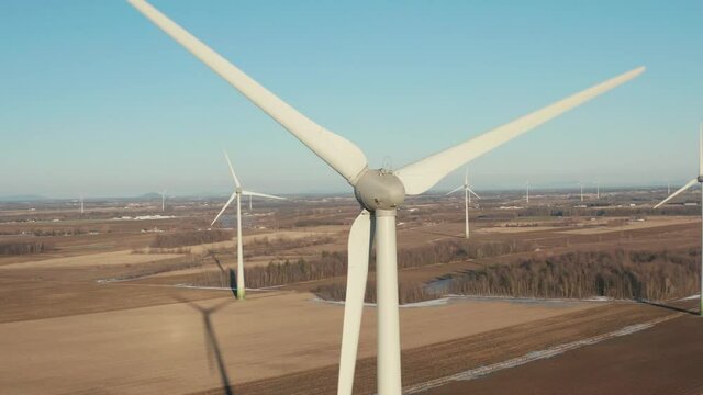 drone approaching to the back of a huge wind turbine getting very close to it, in a very nice sunny day