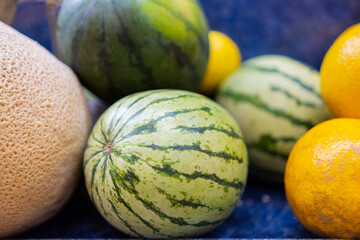 Close-up of colorful fruit stand with watermelons and a oranges