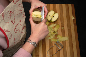 Woman peeling an apple to make homemade donut recipe