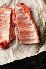 Raw pork ribs with spices, salt and rosemary on dark wooden background. - 431522811