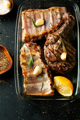 Barbecue ribs and meat with rosemary and garlic on dark background. - 431523066